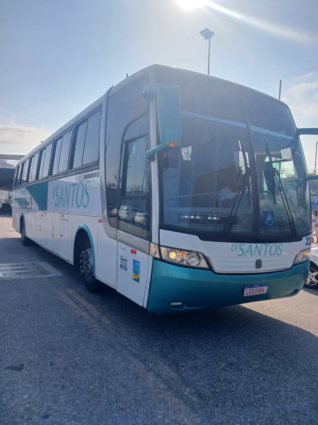 Segundo ônibus D'Santos, visto de lado ao sol