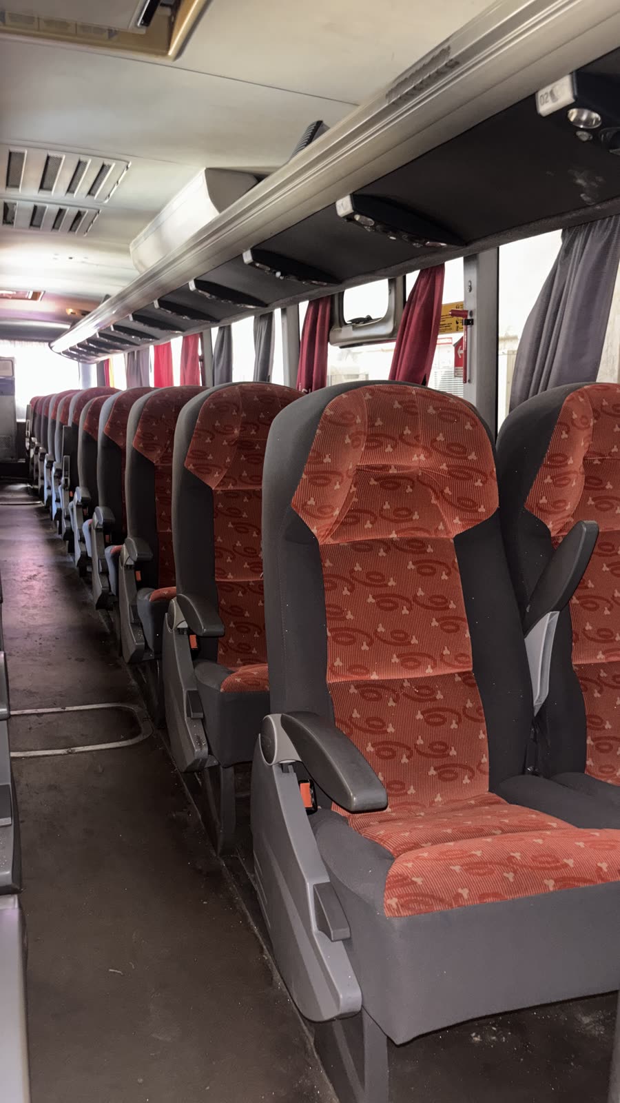 Corredor do ônibus com as poltronas em fila